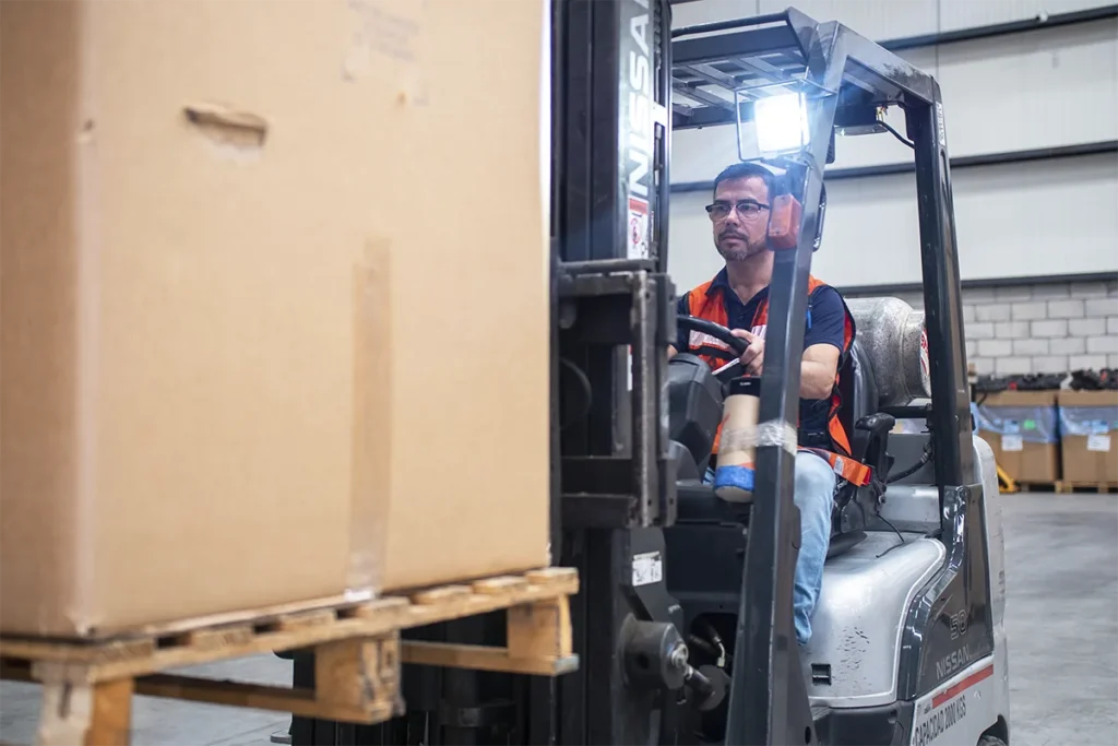 Montacargas organizando productos paletizados en las instalaciones de Onilog, fortaleciendo la cadena de suministro.