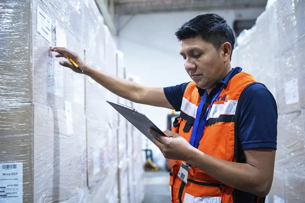 Trabajador de Onilog verificando y clasificando mercancía en almacén para mantener el orden logístico.